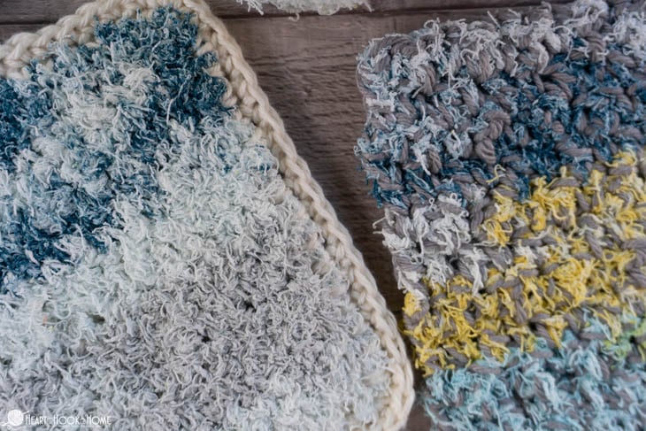 White, gray, blue, and yellow colorway of the cotton yarn side, and white, gray, and blue colorway of the scrubby yarn side of two examples of the Two-Sided Scrubby Dishcloth.