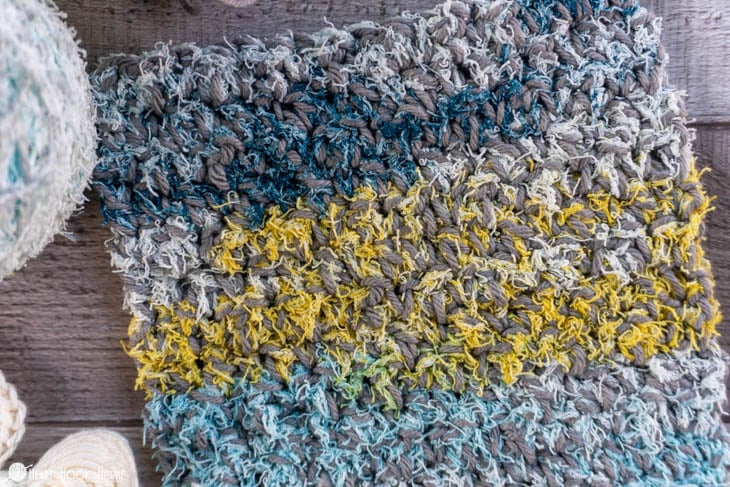 White, gray, blue, and yellow colorway of the cotton yarn side of an example of the Two-Sided Scrubby Dishcloth.
