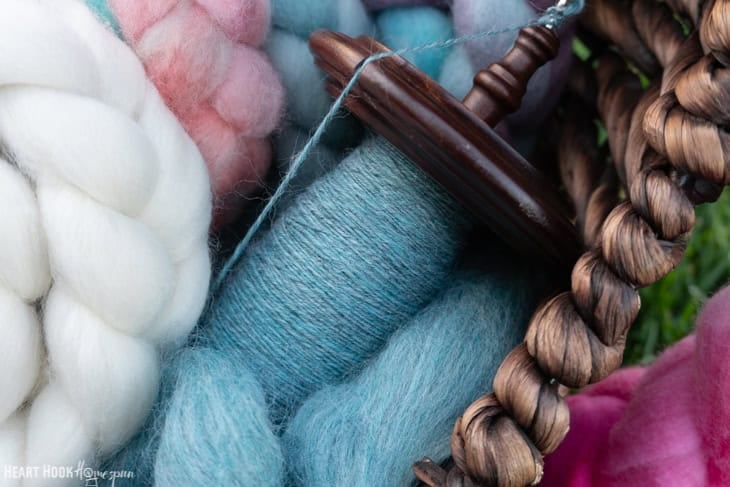 Several colors of Peruvian Highland Wool roving from WeCrochet on a Kromski drop spindle.