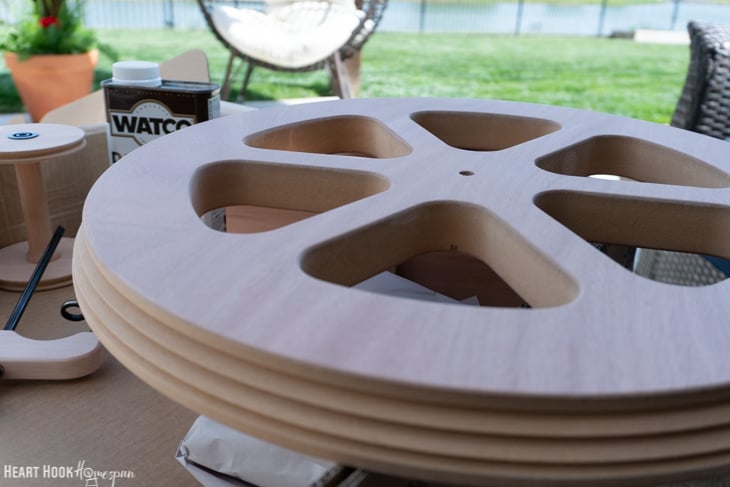 Unfinished spinning wheel in a backyard setting.