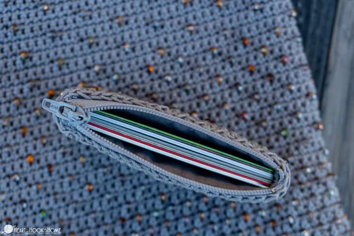 Gray sample of the Cross-Body Bead Bag crochet pattern with natural colored beads with an example of the credit card wallet size on top.