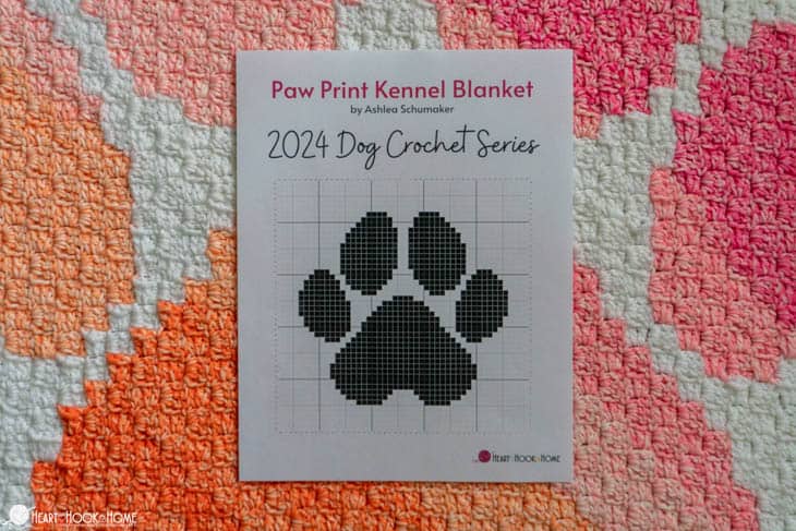 Corner to Corner Paw Print Kennel Blanket crochet pattern with a graph of the pattern laying on it.