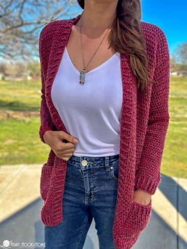 The Camille Cardi on a female model with her hand in its pocket in a sunny park setting.
