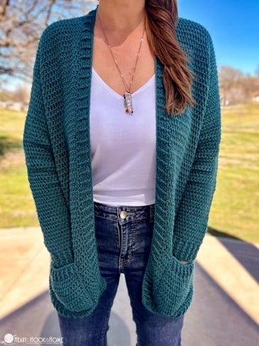 The Camille Cardi on a female model with both hands in the cardigan\'s pockets.