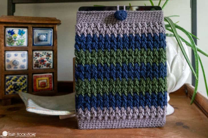 ipad in crocheted sleeve on bookcase