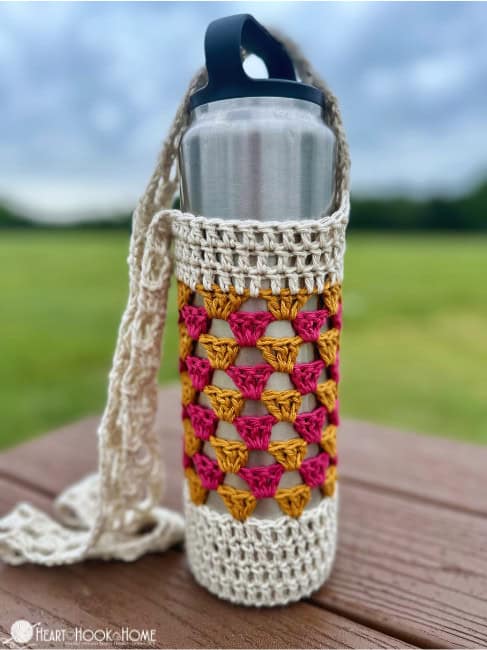 crochet water bottle cozy on park bench