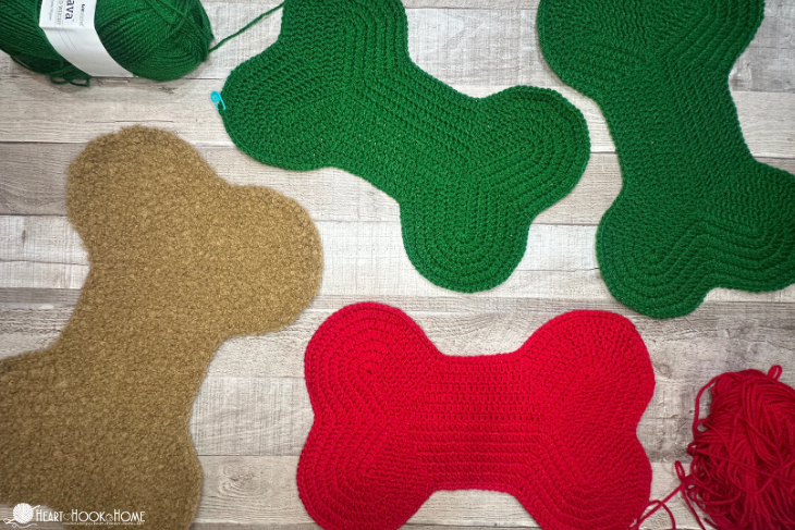 Brown, green, and red examples of the Dog bone Christmas Stocking crochet pattern.