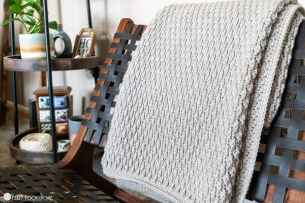 alpine stitch crochet blanket on woven chair